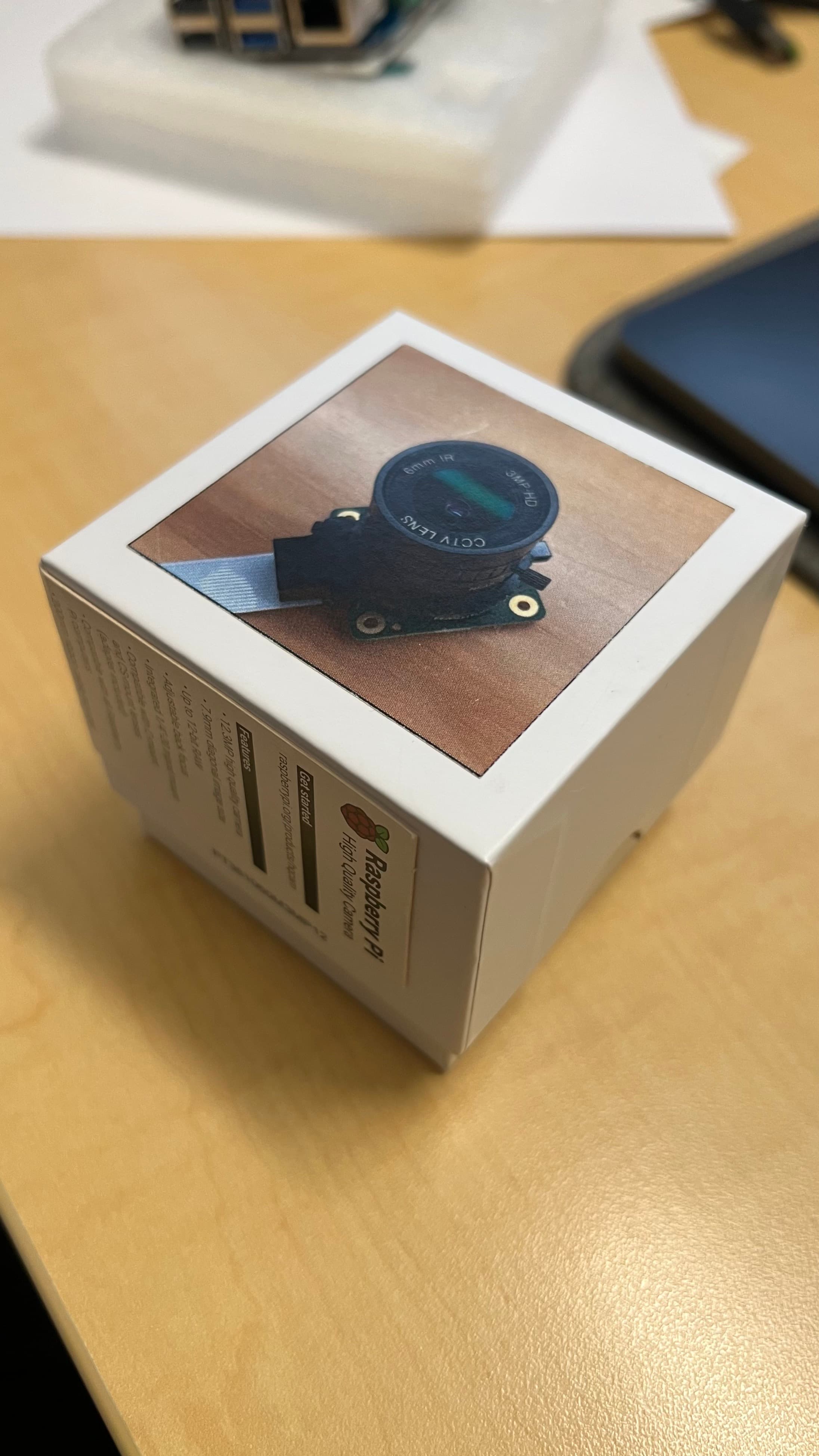 Raspberry Pi camera module box showing the CCTV-style camera lens planned for Ticker Cube.